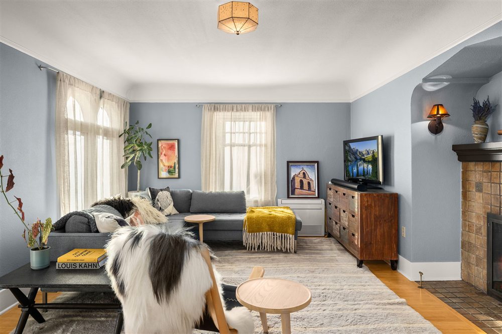 Living room with original arched details and a tiled fireplace